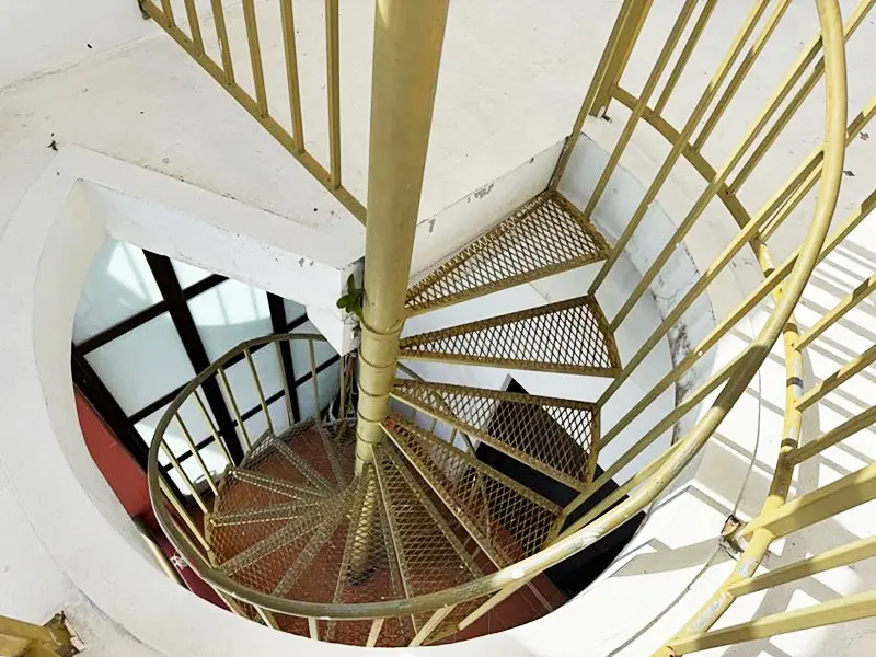 A spiral staircase with wooden steps and metal railing.