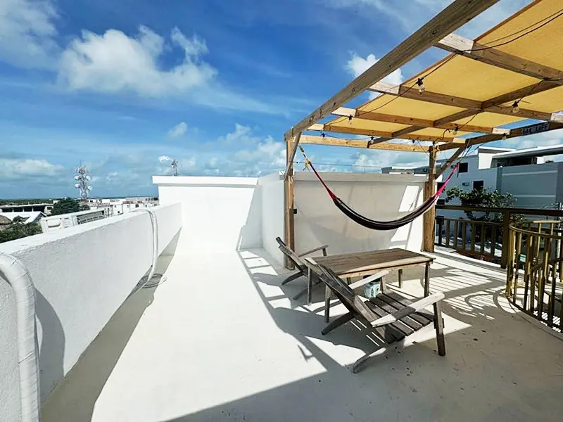 A hammock is hanging on the roof of a building.