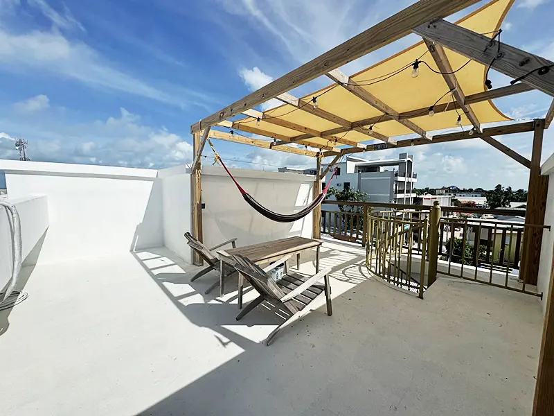 A hammock is on the patio of this rooftop deck.