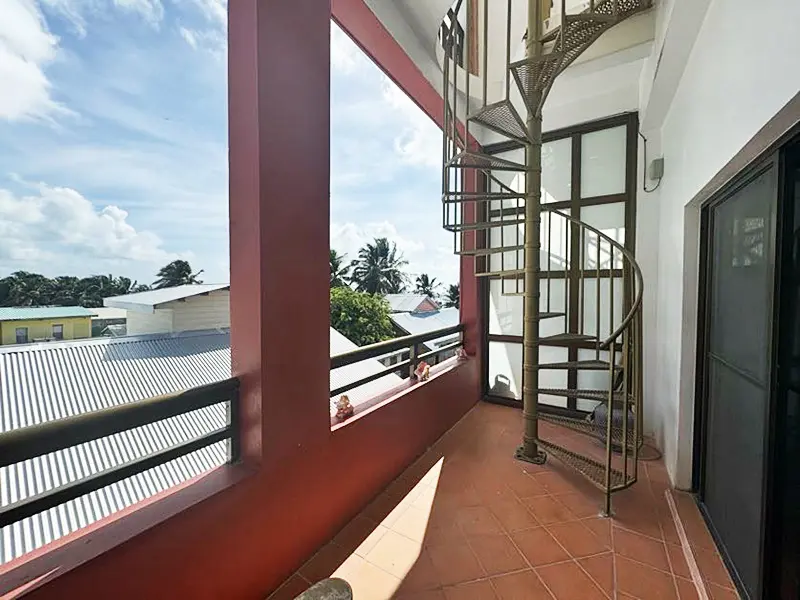 A balcony with a spiral staircase and a fire escape.